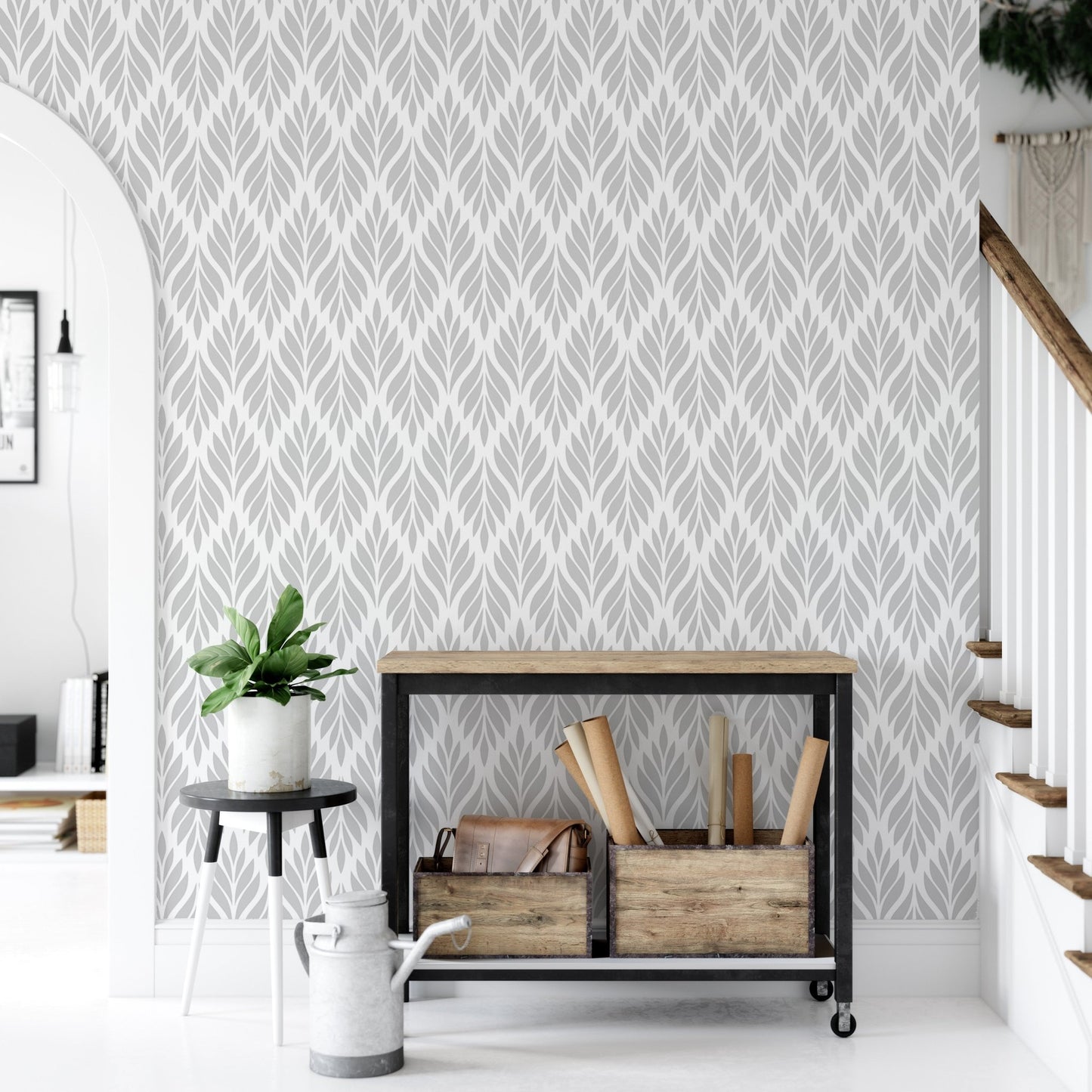 Leaves pattern wallpaper in an entryway with a black metal console table.