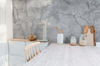 Monochrome forest sketch wall mural behind a white kitchen dining table.