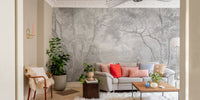 Hand-drawn forest wall mural in a contemporary sitting room with green plants.