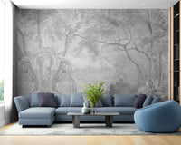 Grey etched tree wall mural in a living room with a blue sofa and wooden flooring.