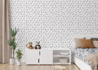 Bedroom with white storage unit and grey polka dot wallpaper.