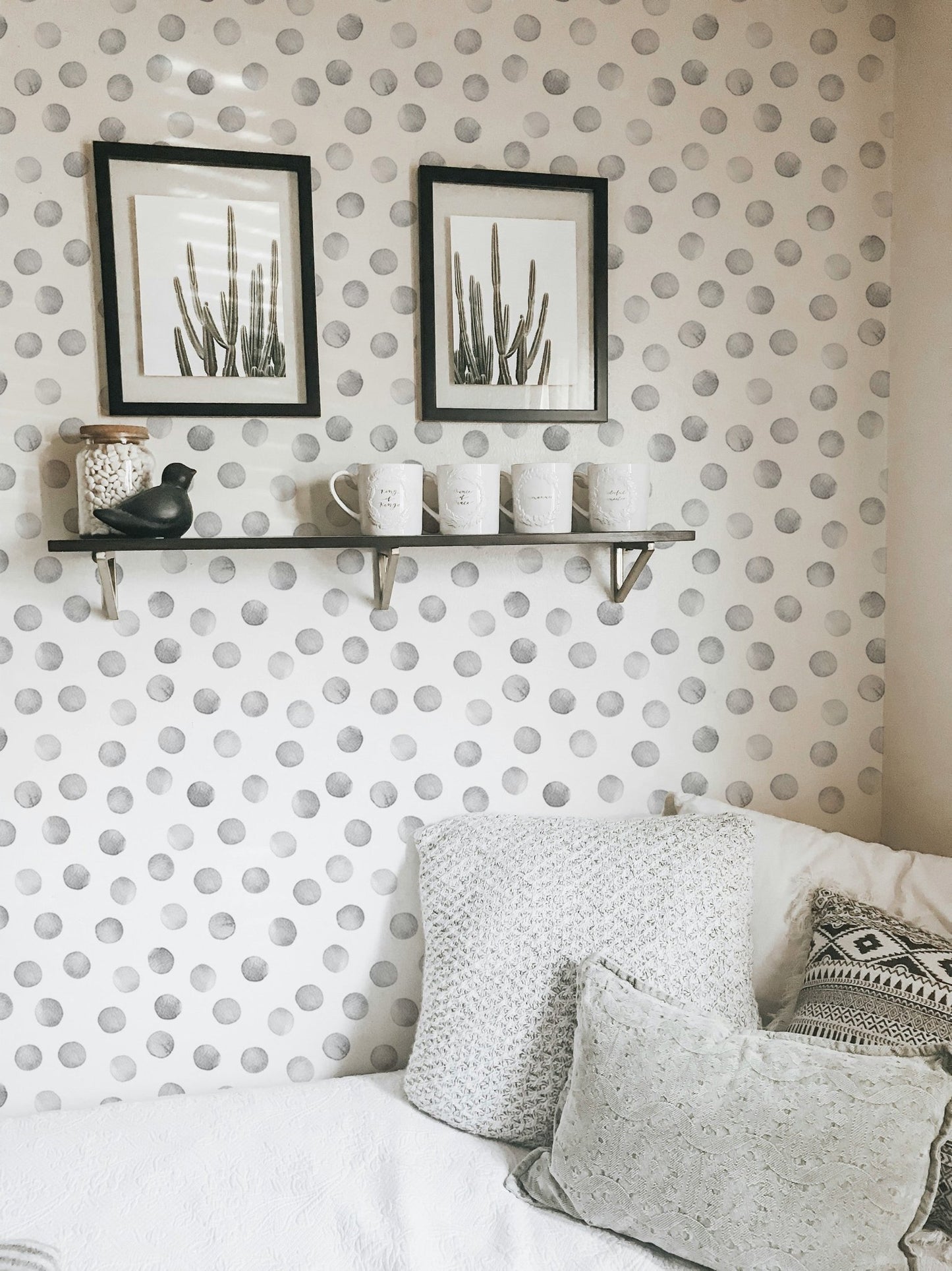 Living space with wall shelves and grey polka dot wallpaper.