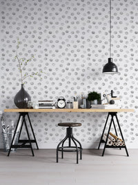 Industrial office with black trestle desk and grey polka dot wallpaper.
