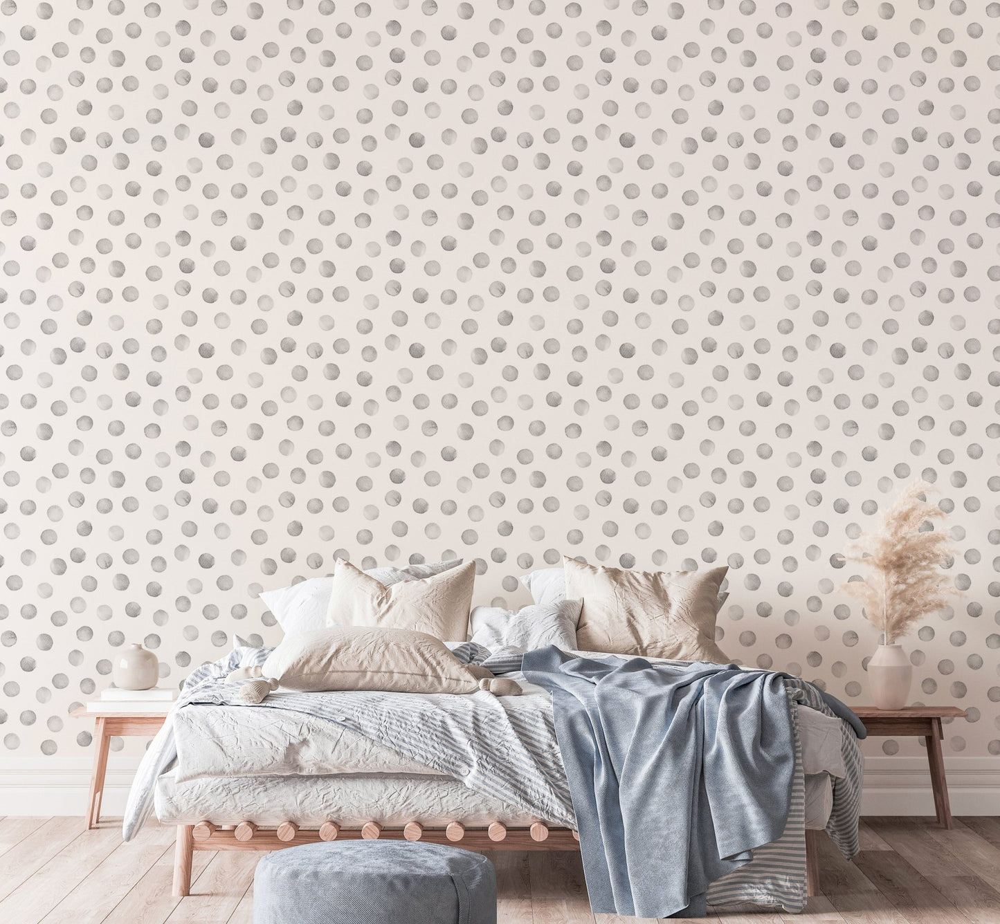 Bedroom with blue linens and grey polka dot pattern wallpaper on the main wall.