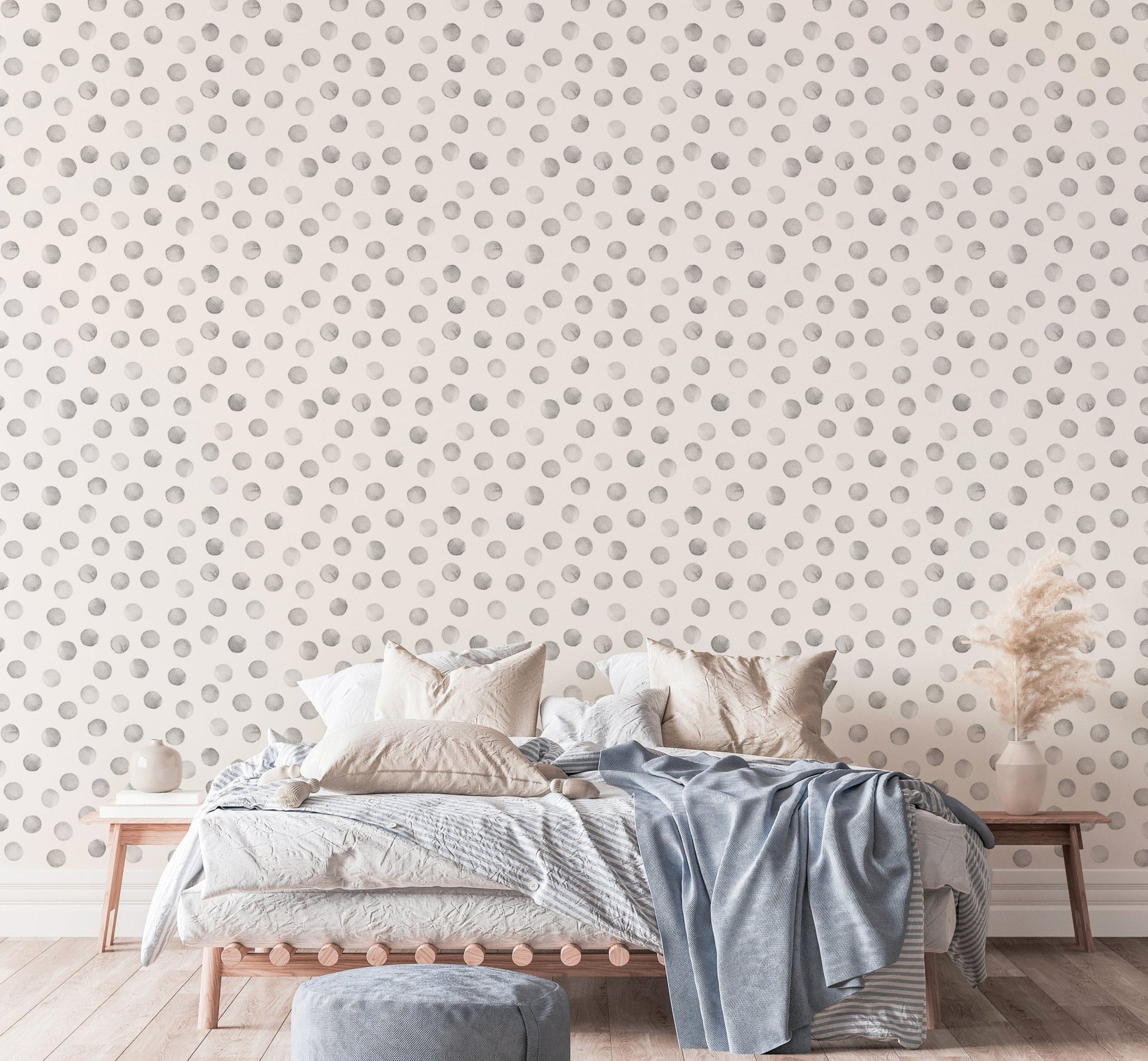 Bedroom with blue linens and grey polka dot pattern wallpaper on the main wall.