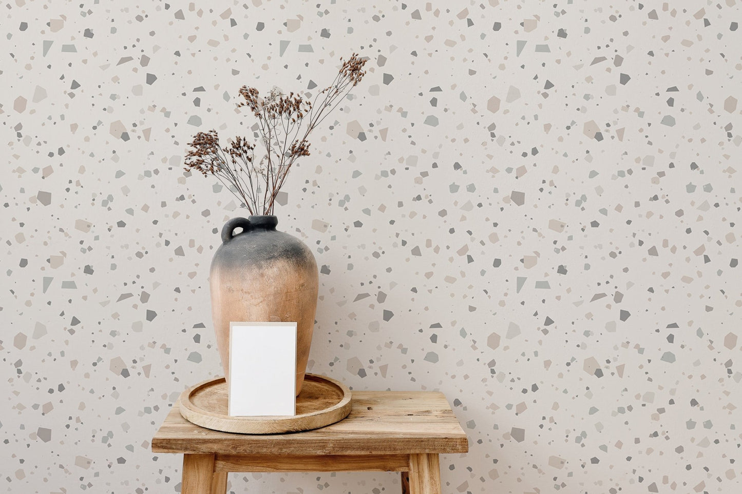 Speckled granite pattern wall mural behind a minimalist wooden stool and vase.