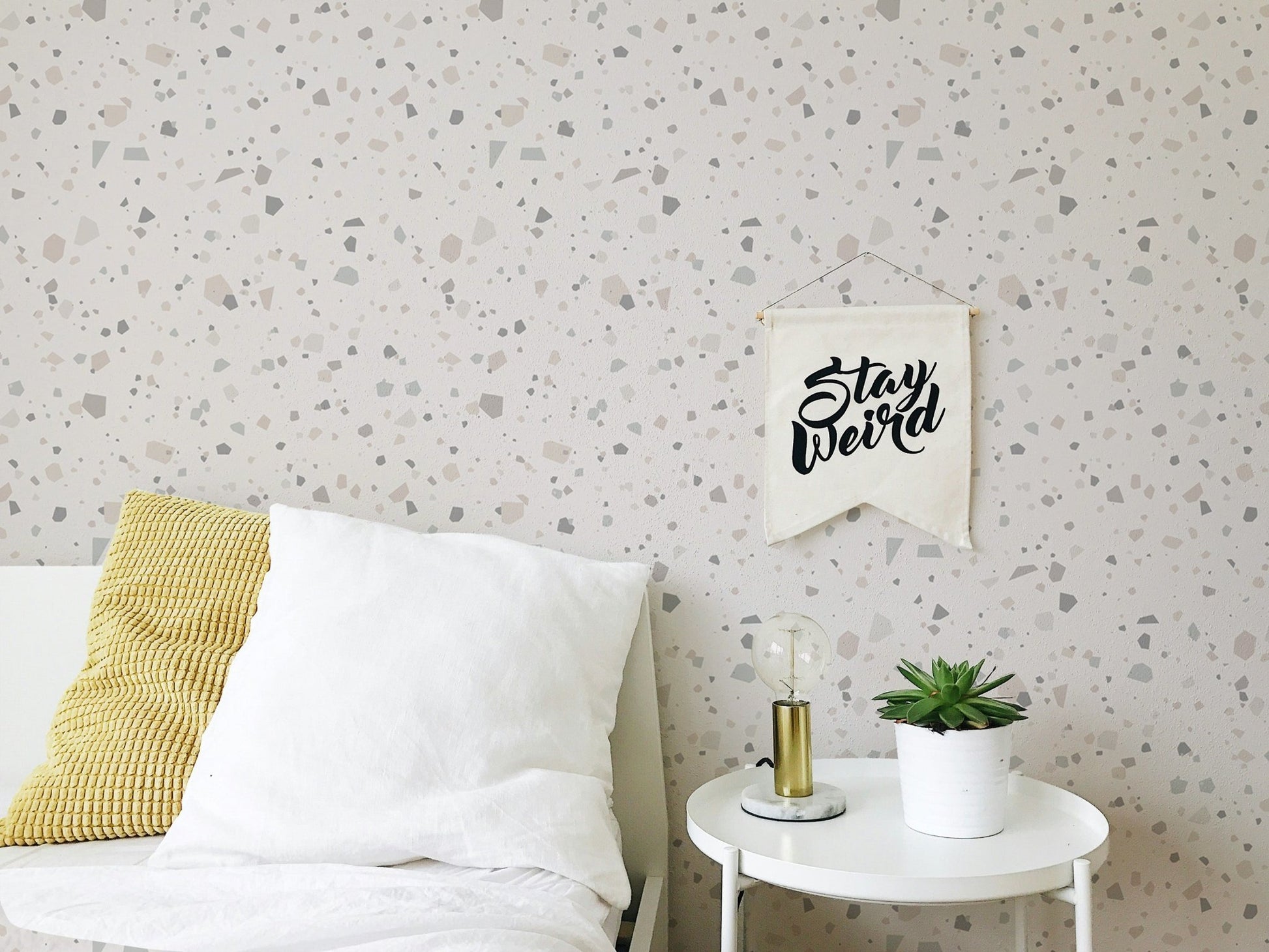 Stone pattern wall mural behind a white sideboard in a child's bedroom.