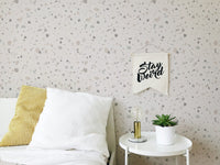 Stone pattern wall mural behind a white sideboard in a child's bedroom.