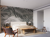 Minimalist bedroom with a large palm leaves wall mural.