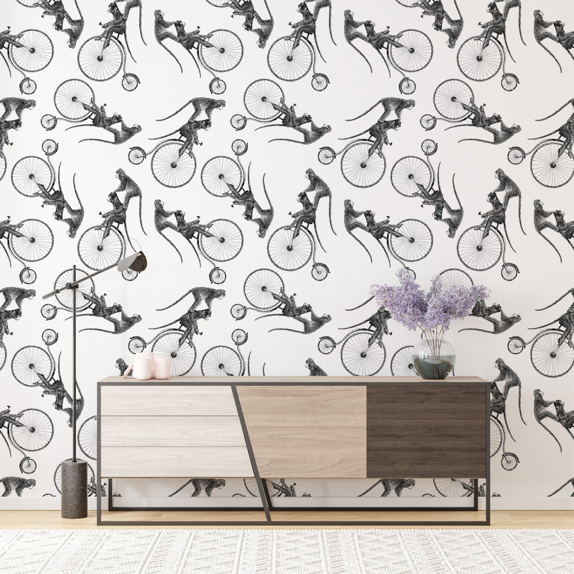 Hand drawn monkey on bike wallpaper above a modern wooden sideboard cabinet.