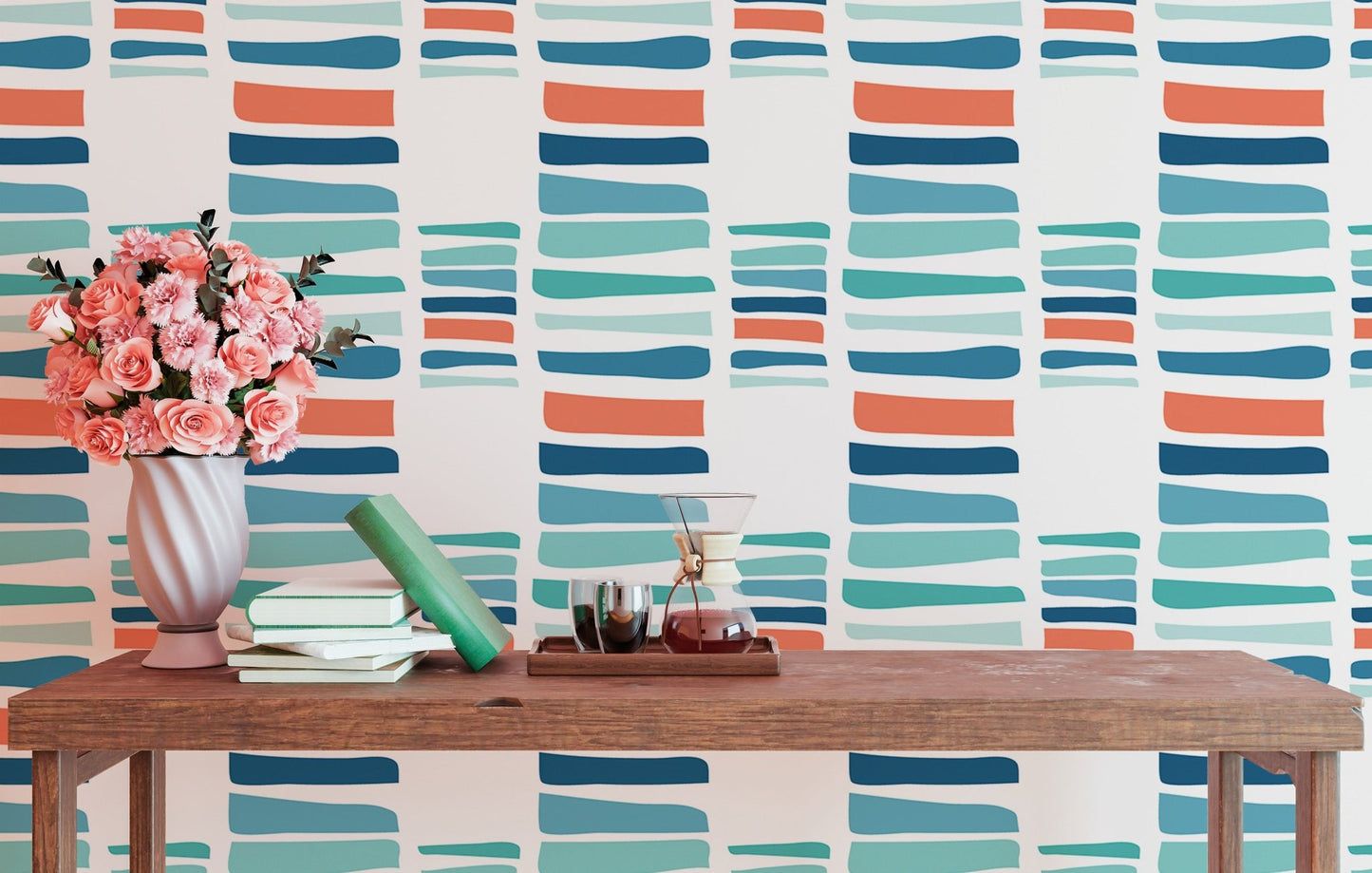 Multi-color brush stroke stripe wallpaper behind a wooden table with pink flowers.