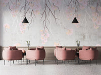 Hanging flower branches on a pink wall mural in a cafe.