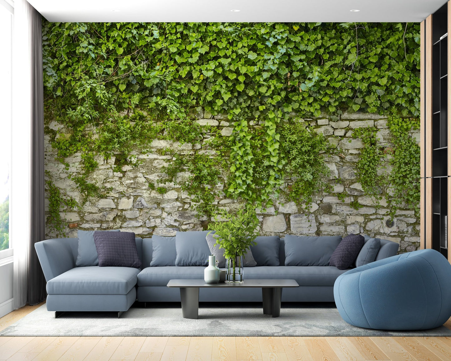 Realistic green leaf wallpaper mural in a living area with a blue sectional sofa.