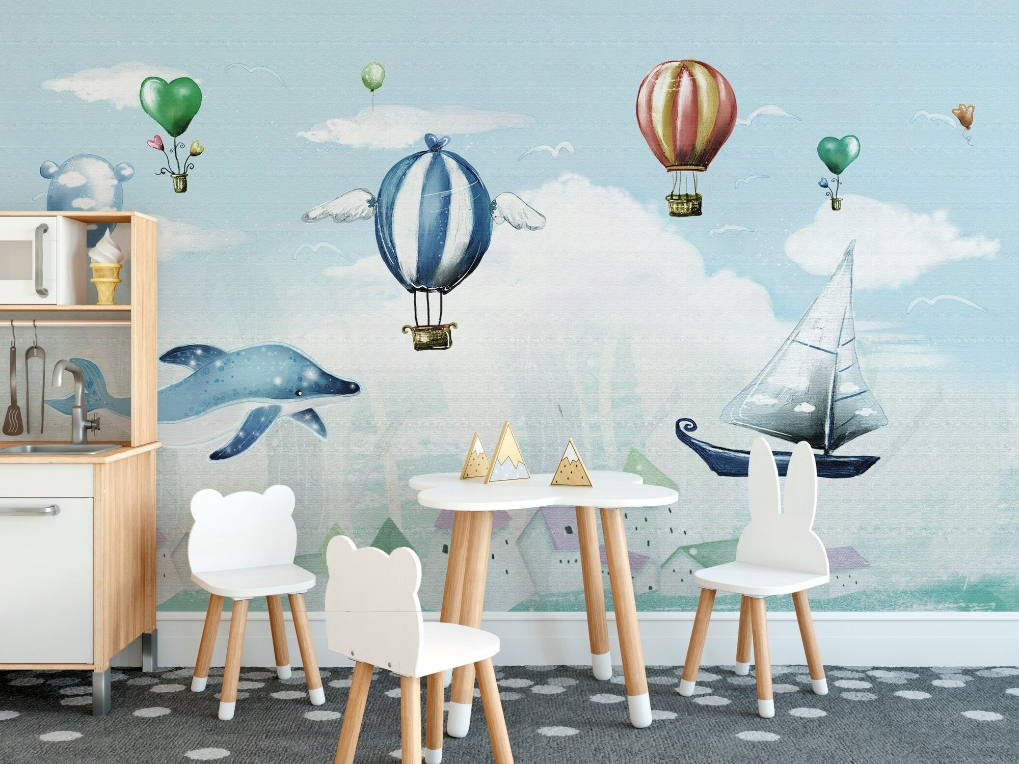 Blue hot air balloon wall mural in kids dining area with white table.