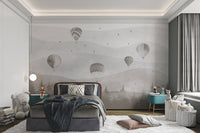 Artistic hot air balloons floating over hills wall mural in kids bedroom.