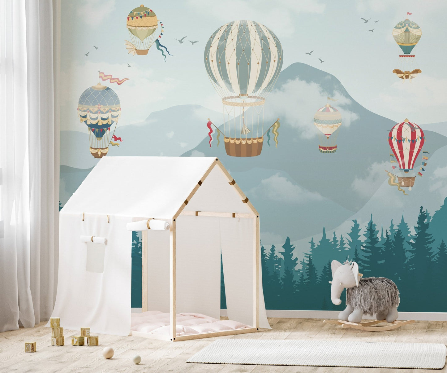 Mountain peak wall mural in modern nursery with hot air balloon pattern.
