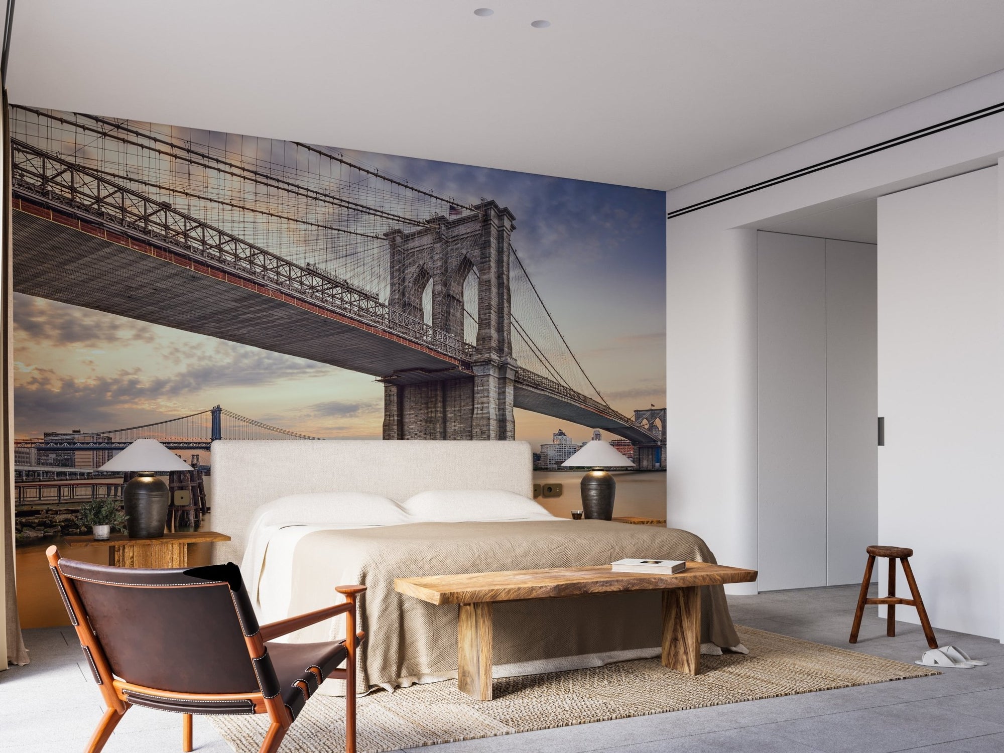 Brooklyn Bridge wall mural in a modern bedroom with a wooden bench.