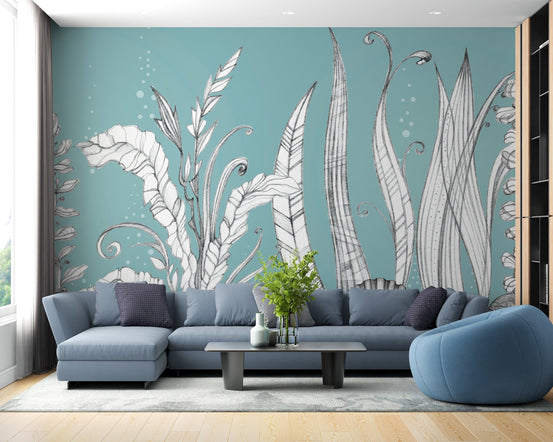 Blue floral wall mural behind a blue sectional sofa in a bright lounge.