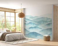 Sunlit bedroom with indigo blue watercolor waves wall mural on a feature wall.