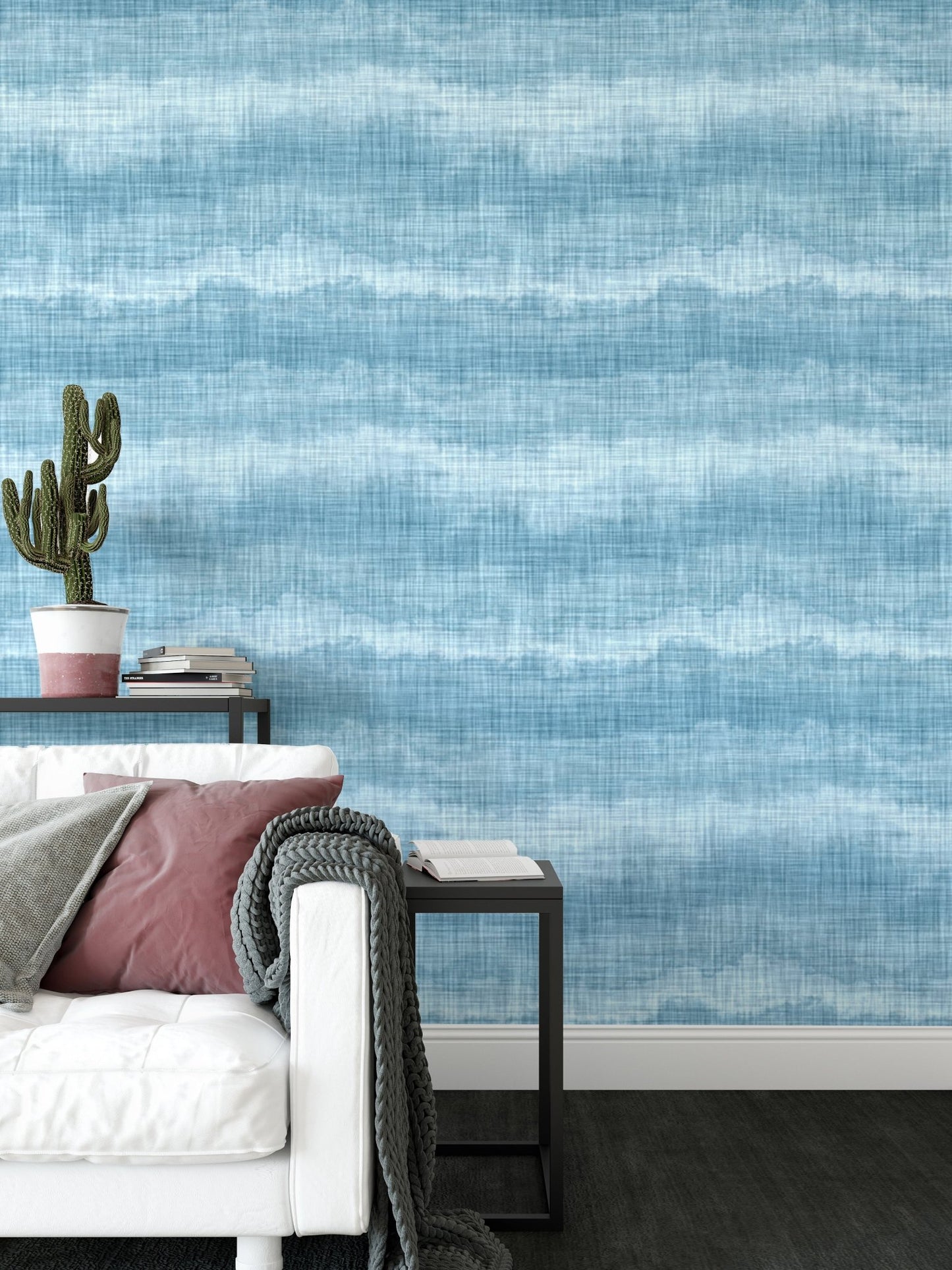 Indigo blue wavy stripe wallpaper behind a white sofa and black side table.