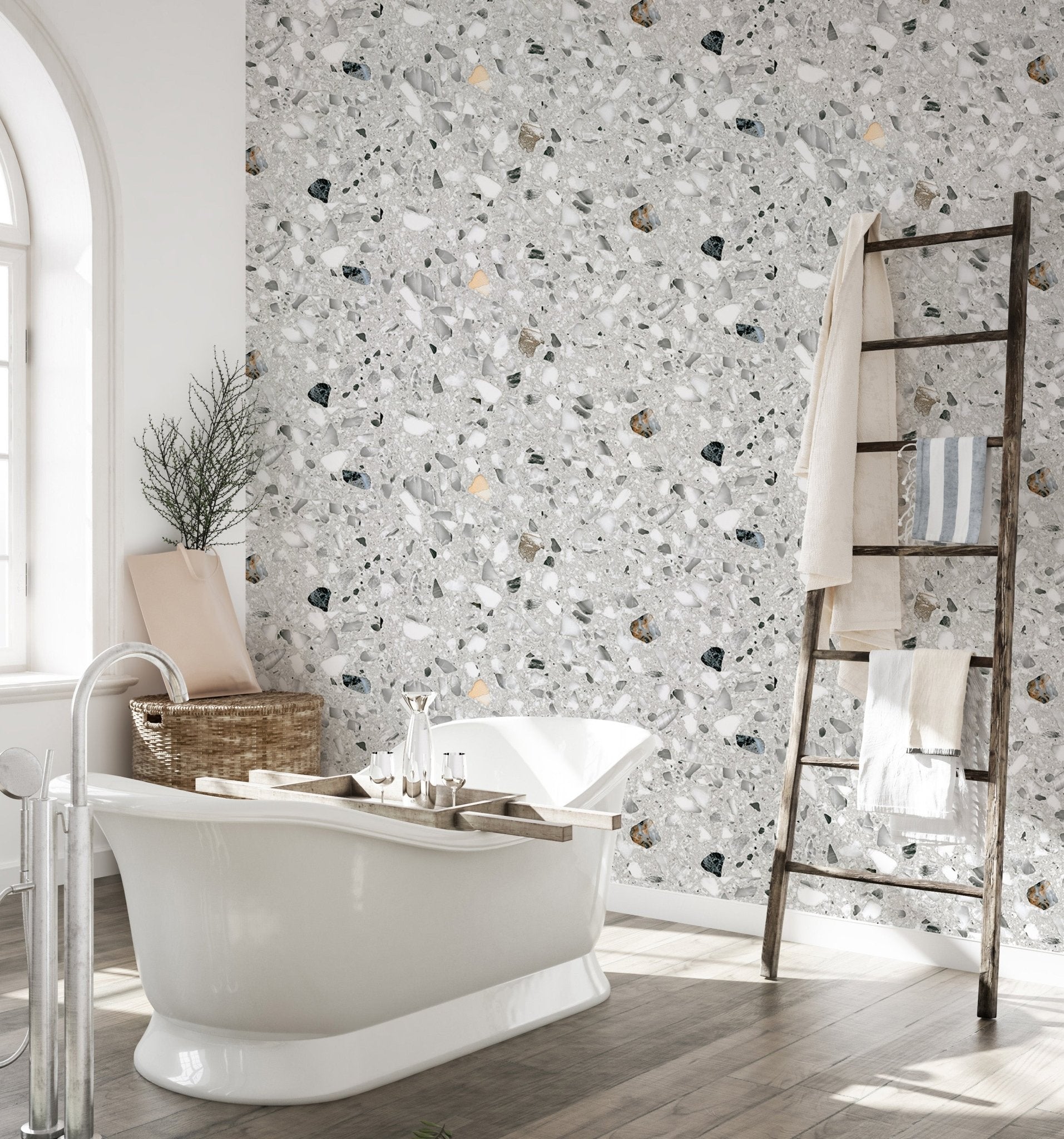 Modern terrazzo wallpaper in a bathroom with a white freestanding tub and ladder.