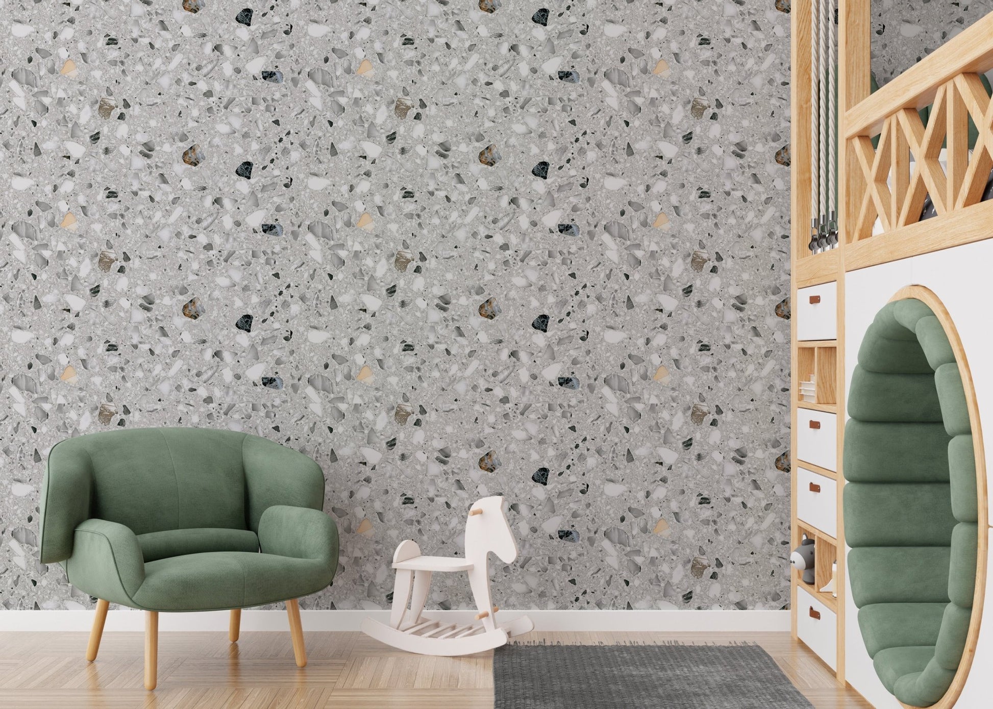Grey terrazzo wallpaper in a kids play area with a green armchair and toy horse.