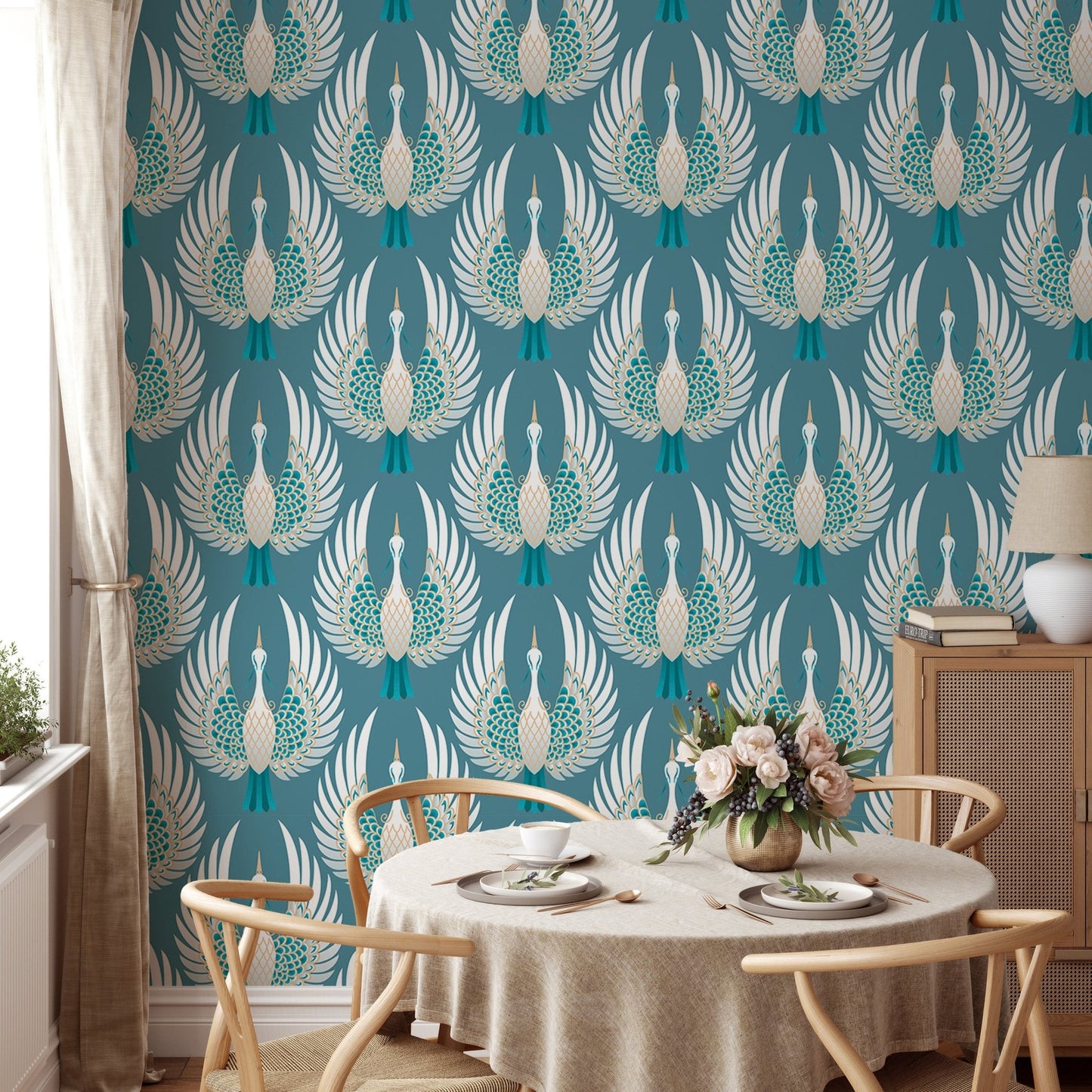 Teal bird wallpaper in a dining room with a round wooden table and chairs.