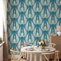 Teal bird wallpaper in a dining room with a round wooden table and chairs.