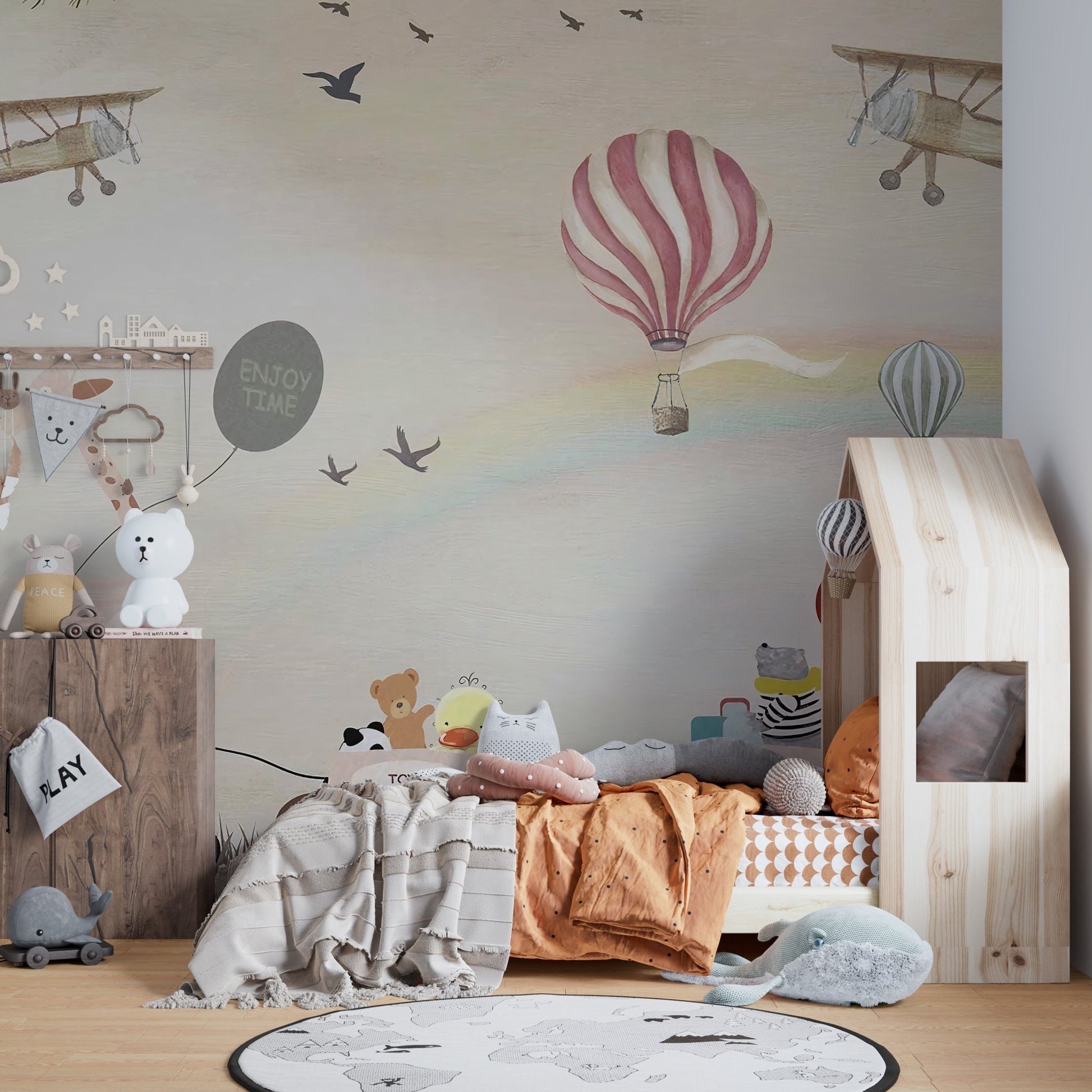 Jovial Animal Parade wall mural behind a wooden house-frame bed.
