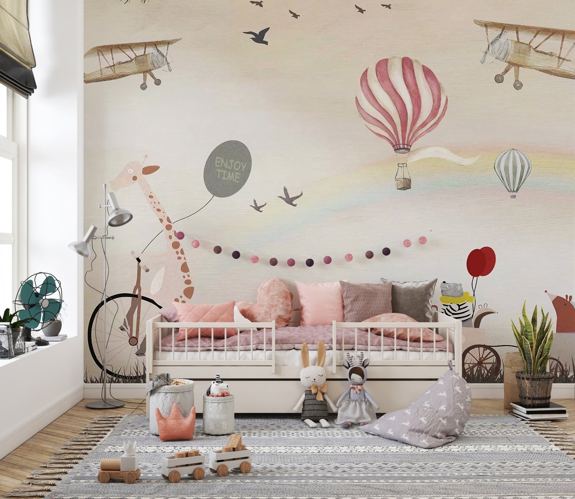 Jovial Animal Parade wall mural behind a toddler daybed with pink cushions.