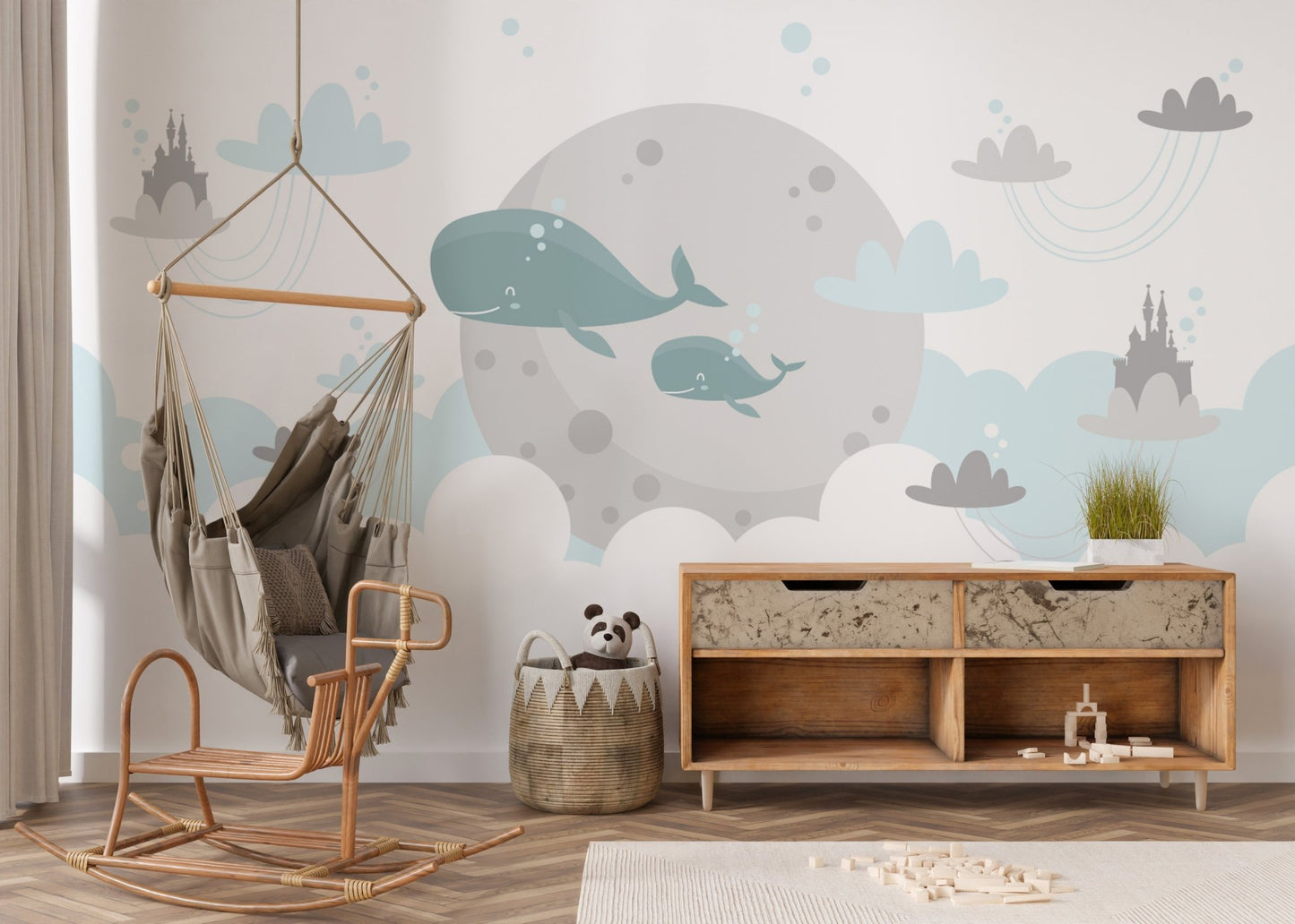 Playroom wall mural featuring whales and clouds behind a wooden rocking chair