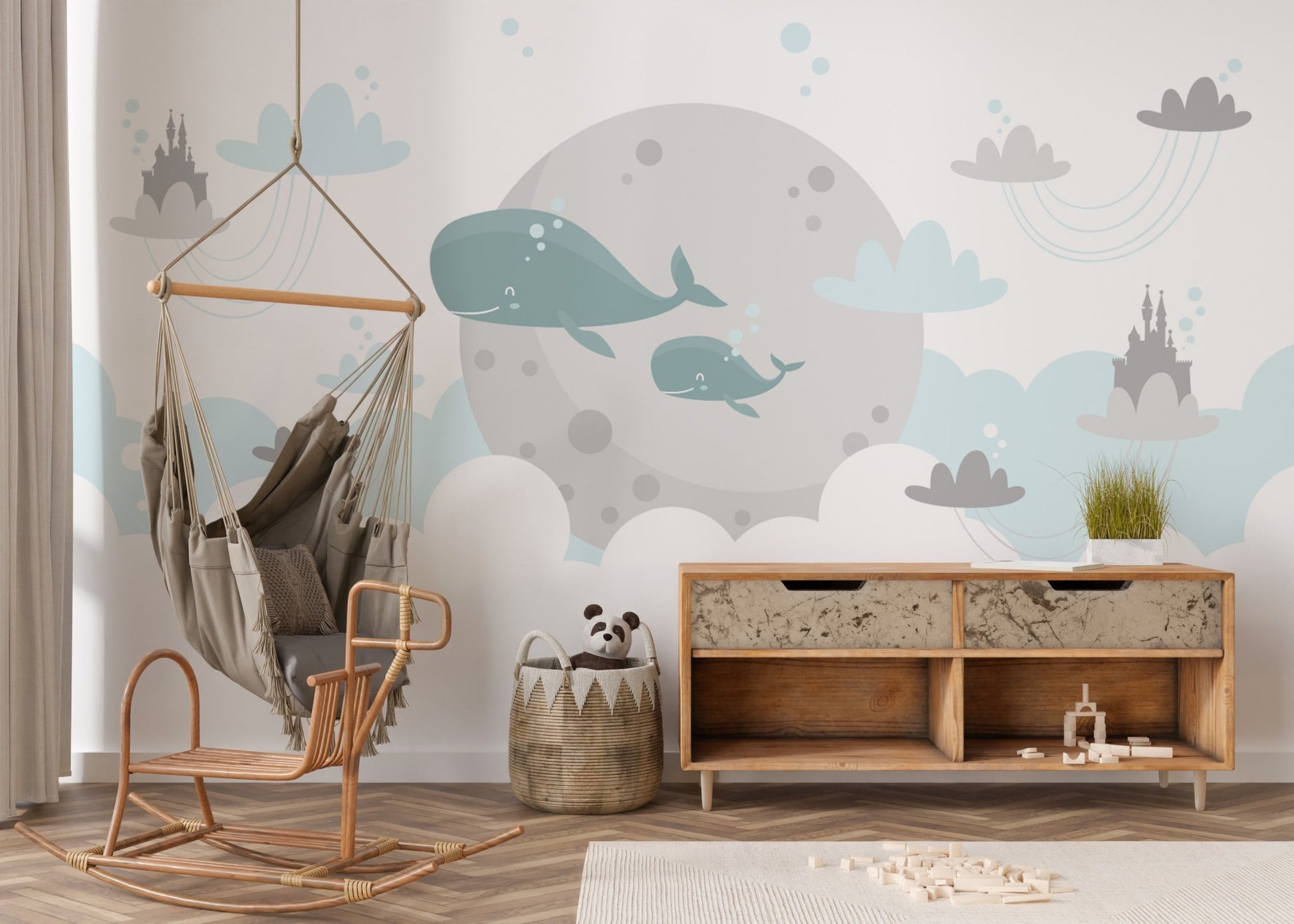 Playroom wall mural featuring whales and clouds behind a wooden rocking chair