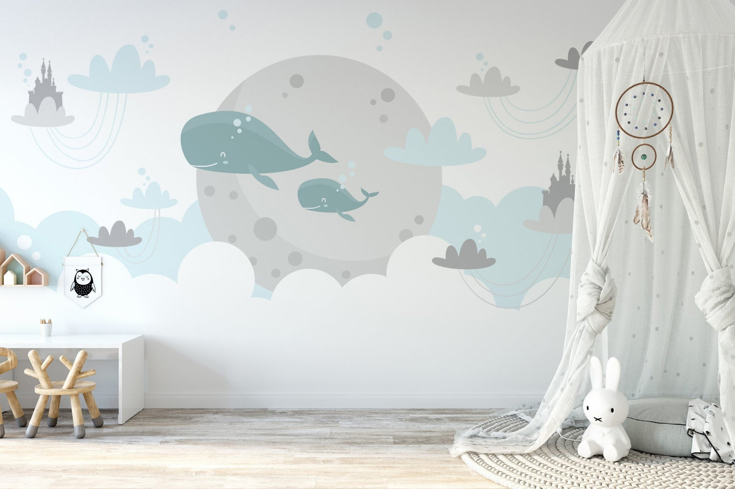 Blue whale wall mural in a nursery with white shelving and neutral decor