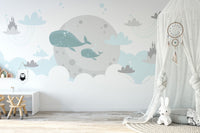 Blue whale wall mural in a nursery with white shelving and neutral decor