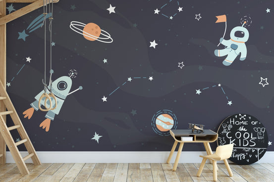 Dreamy astronaut and rocket wall mural in a playroom with wooden furniture.