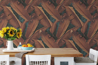 Autumn leaves wallpaper behind a wooden dining table with yellow flowers.