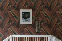 Brown foliage concrete wallpaper behind a white cot in a nursery room.