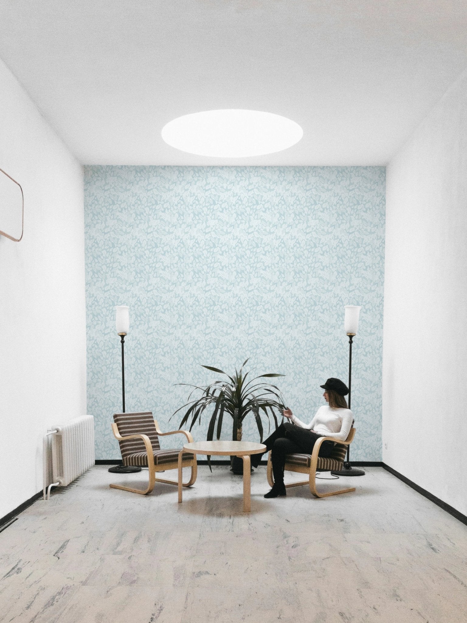 Leaves In Deep Sky Blue Wallpaper in a minimalist sitting room.
