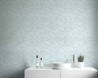 Leaves In Deep Sky Blue Wallpaper behind a white bathroom.