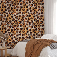 Leopard pattern wallpaper in a bedroom behind a bed with brown linen sheets.