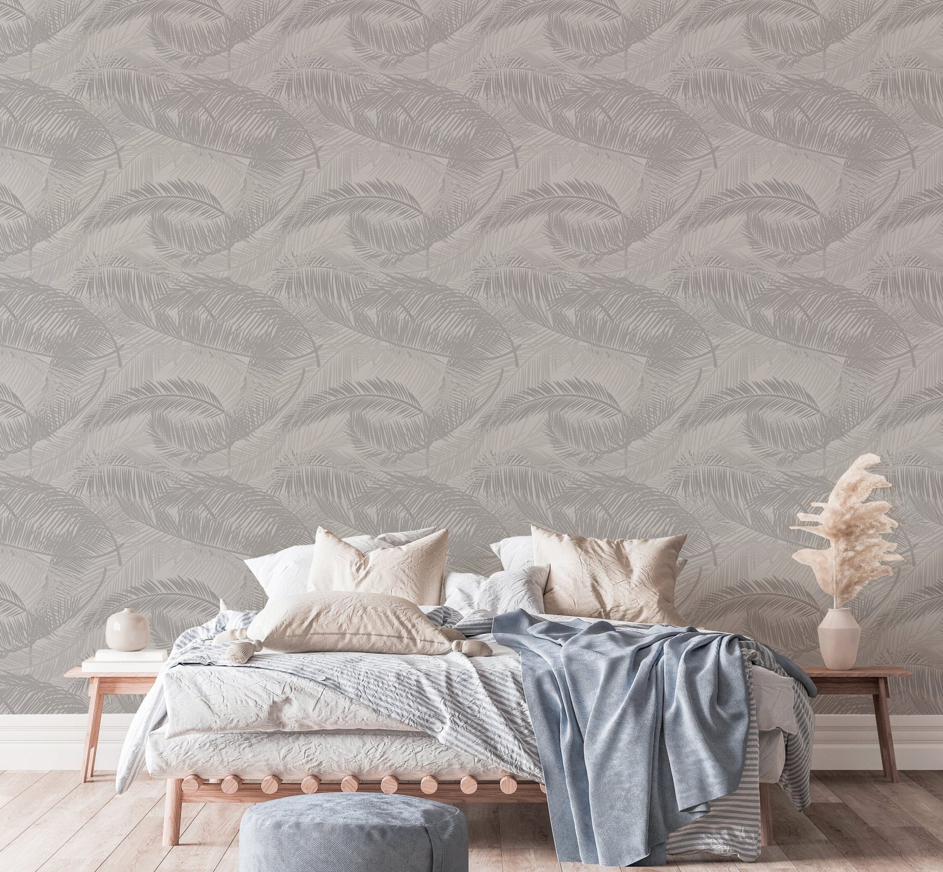 Modern bedroom with neutral bedding and light gray palm leaves wallpaper.