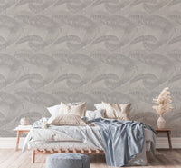 Modern bedroom with neutral bedding and light gray palm leaves wallpaper.