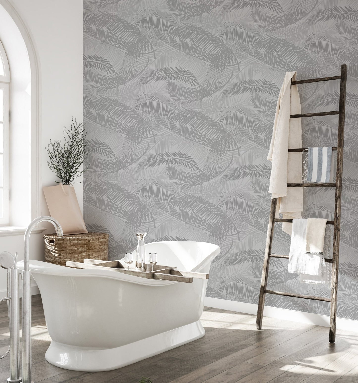 Bathroom interior with white tub and gray tropical palm leaf pattern wallpaper.
