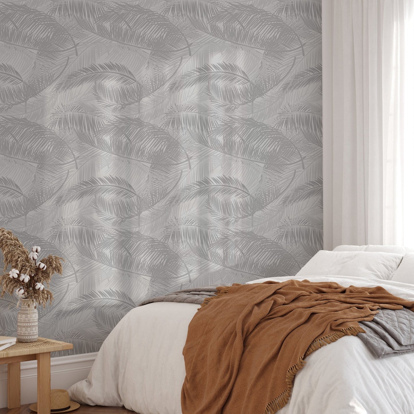 Airy bedroom decor featuring silhouette leaf pattern wallpaper on a feature wall.