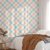 Sunlight hitting a bed with peach and blue geometric stripe wallpaper in the background.