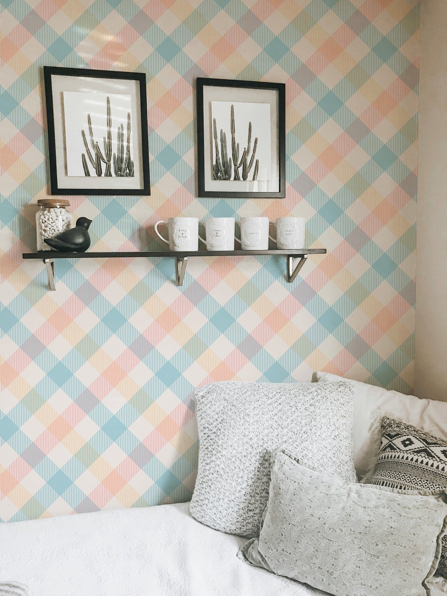 Bedroom corner with framed art on a peach and blue stripe wallpaper.