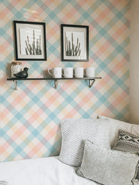 Bedroom corner with framed art on a peach and blue stripe wallpaper.