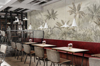 Tropical palm tree mural with muted yellow and grey tones on a cafe wall.