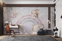 Soft purple wall mural with little girls and unicorns hugging under a rainbow.