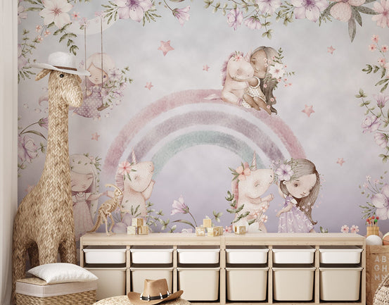 Fairy tale wall mural showing girls playing with unicorns near a rainbow.